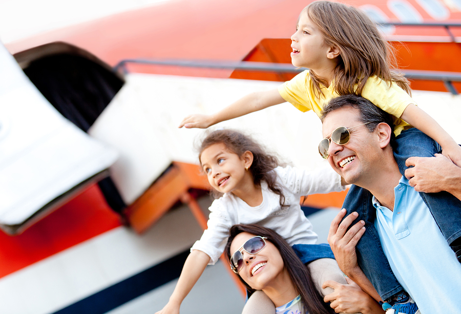 Excited family standing by plane